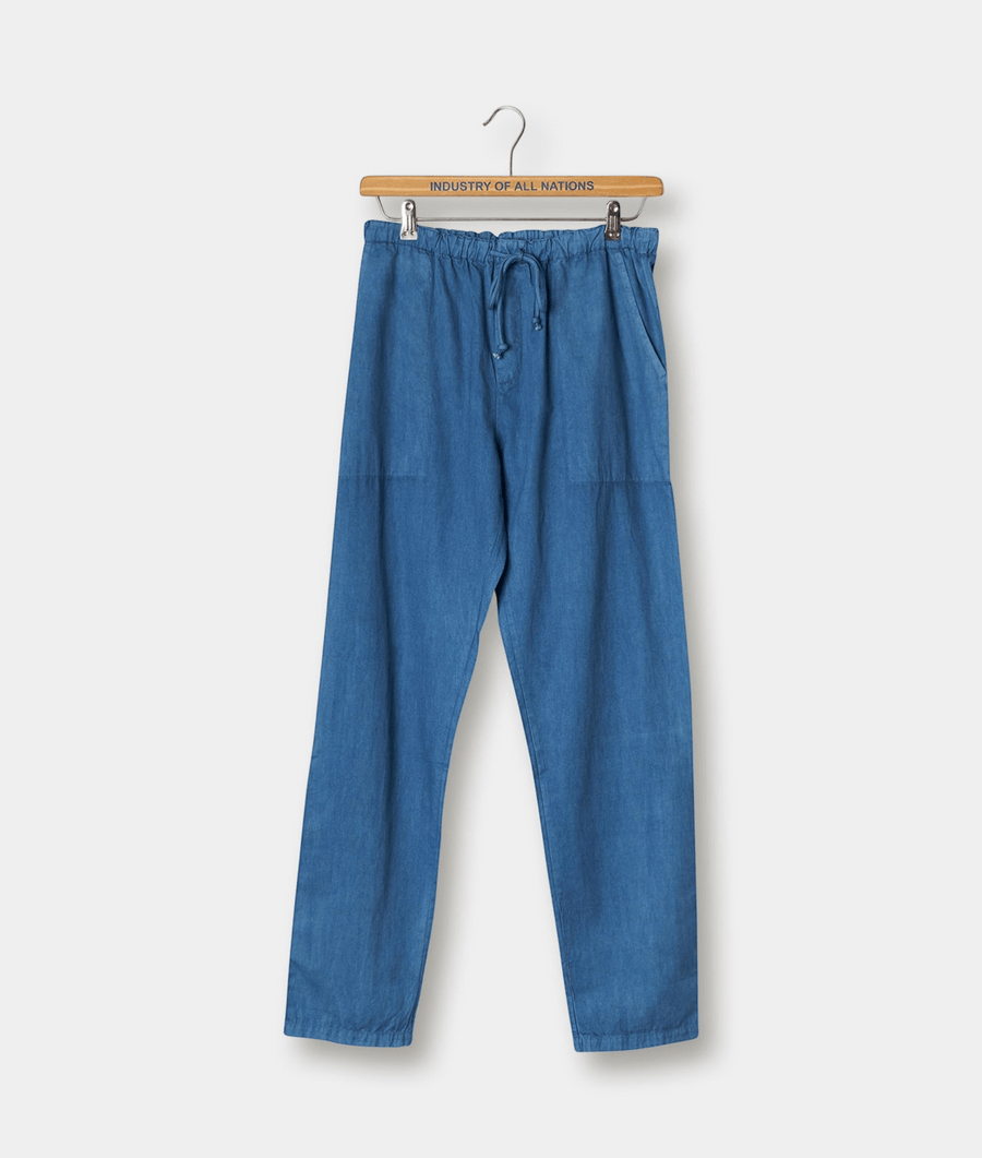 Blue denim drawstring pants displayed on a wooden hanger with "Industry of All Nations" text - Industry of All Nations