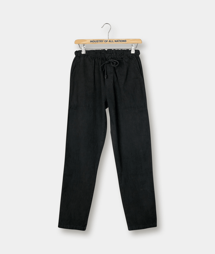Black drawstring pants hanging on a wooden hanger with "Industry of All Nations" logo - Industry of All Nations