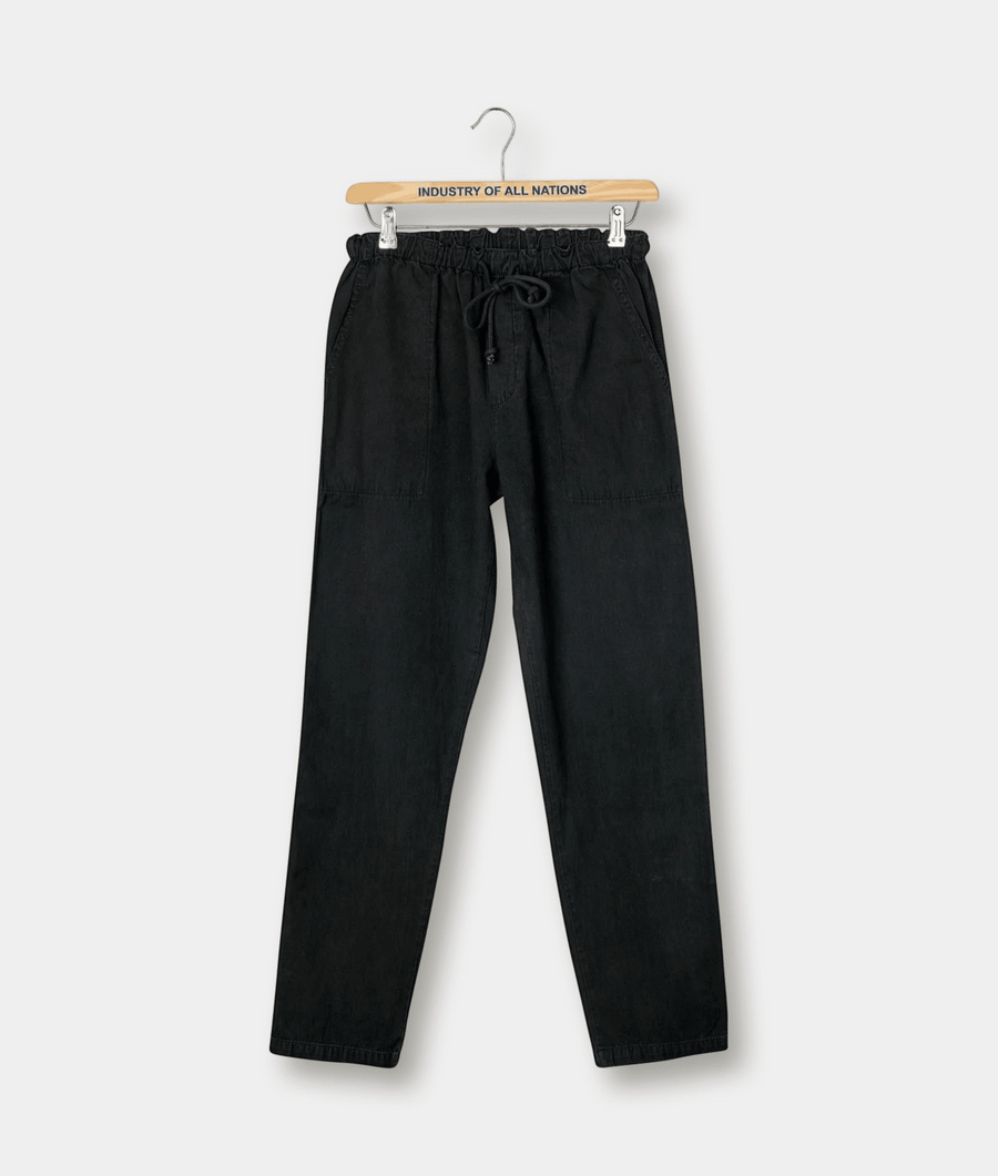 Black drawstring pants hanging on a wooden hanger with "Industry of All Nations" logo - Industry of All Nations