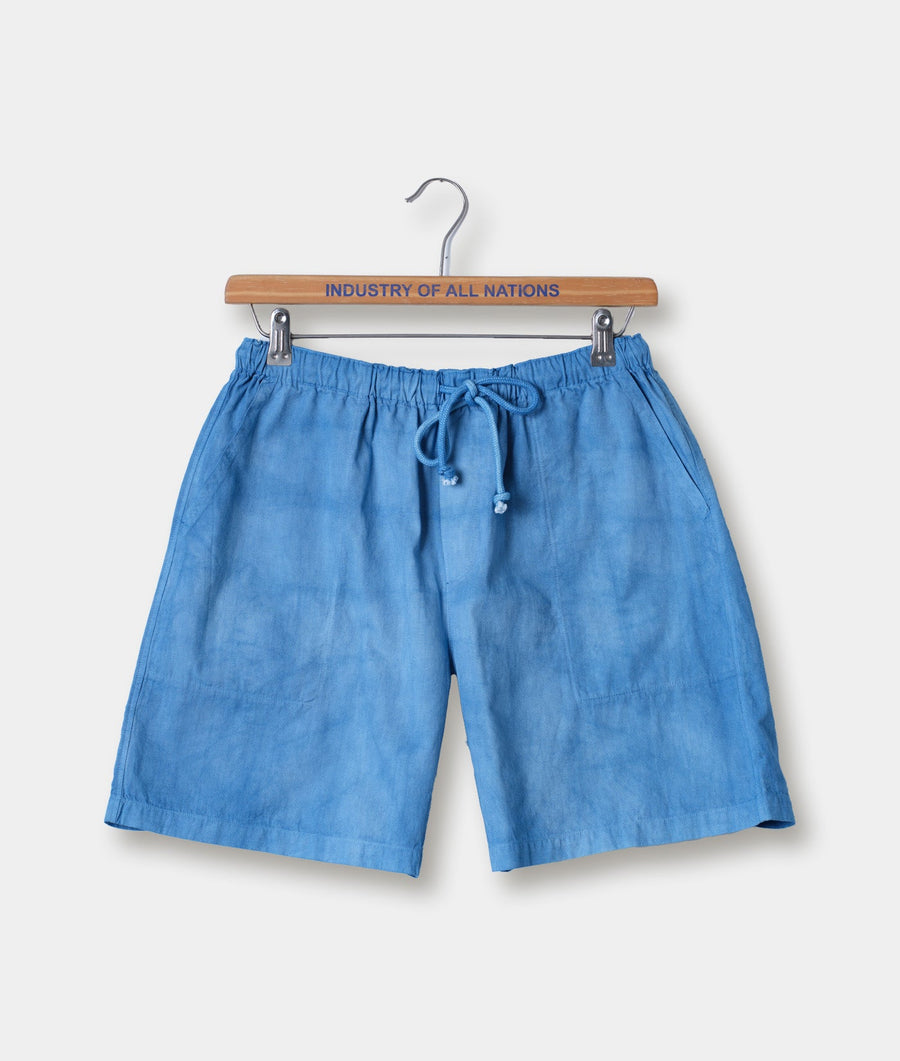 Blue linen drawstring shorts hanging on a wooden hanger with the brand name "Industry of All Nations" printed on it - Industry of All Nations