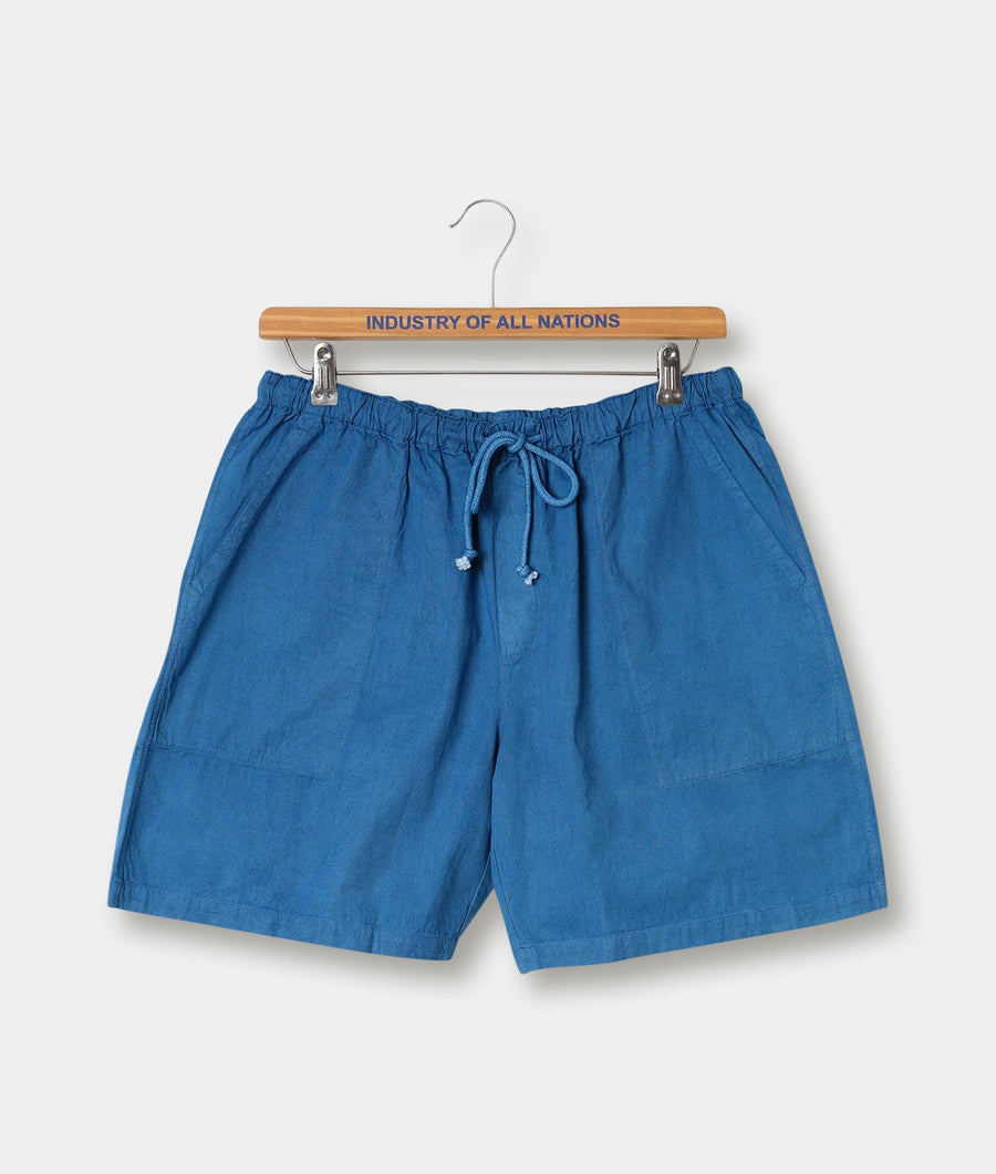 Blue cotton shorts with drawstring waist, hanging on a wooden hanger with "Industry of All Nations" text - Industry of All Nations