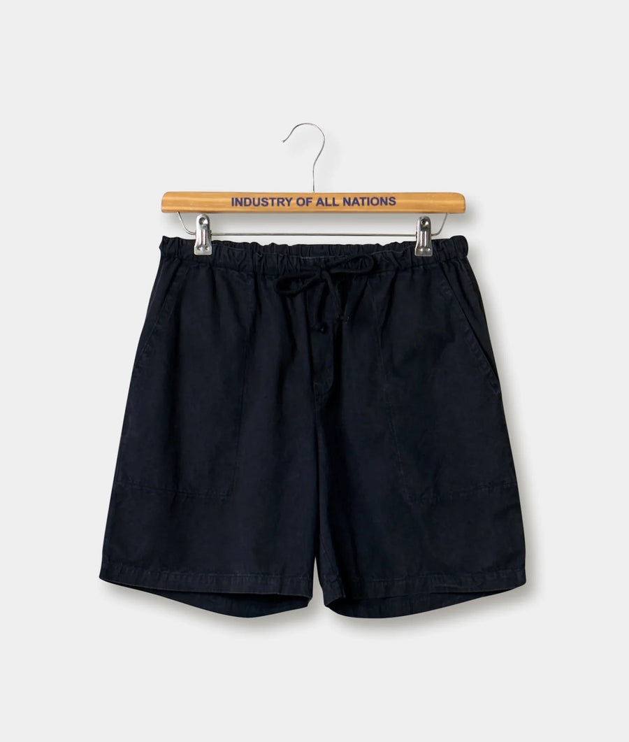 Black drawstring shorts hanging on a wooden hanger with "INDUSTRY OF ALL NATIONS" printed on it - Industry of All Nations