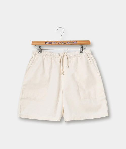 Cream-colored casual cotton shorts with drawstring waist, displayed on a wooden hanger labeled "Industry of All Nations" - Industry of All Nations