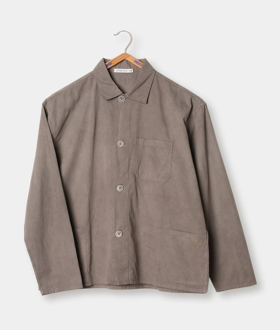 Tan-colored button-up jacket from Industry of All Nations, displayed on a hanger against a plain white background.