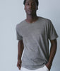 Model wearing a fine grey and white striped cotton tee with natural pants - Industry of All Nations
