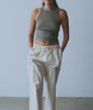 Woman in an olive ribbed tank top and natural drawstring pants in a studio - Industry of All Nations