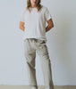 Man wearing a white t-shirt and grey drawstring pants, against a white background