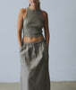 Woman wearing a grey ribbed tank and cotton maxi skirt against a white studio background