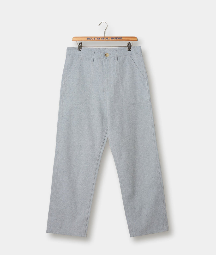 Light gray cotton chino trousers displayed on a wooden hanger with a "Industry of All Nations" branded label - Industry of All Nations