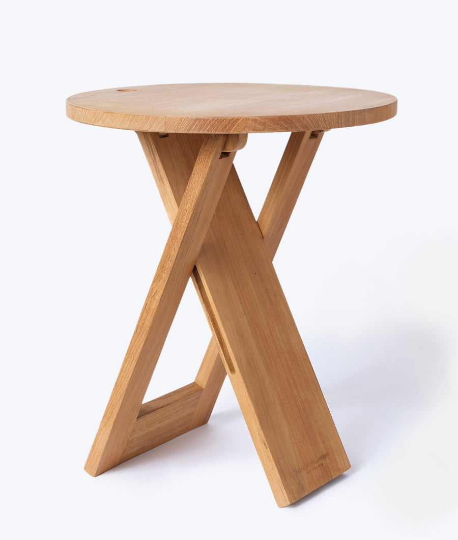 A round wooden side table with an X-shaped base design - Industry of All Nations