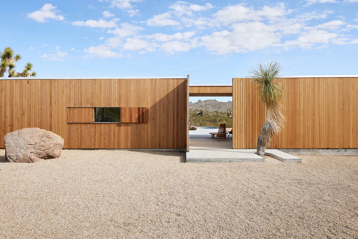 Cedar-clad Landing House in Joshua Tree, with a shaded open courtyard
