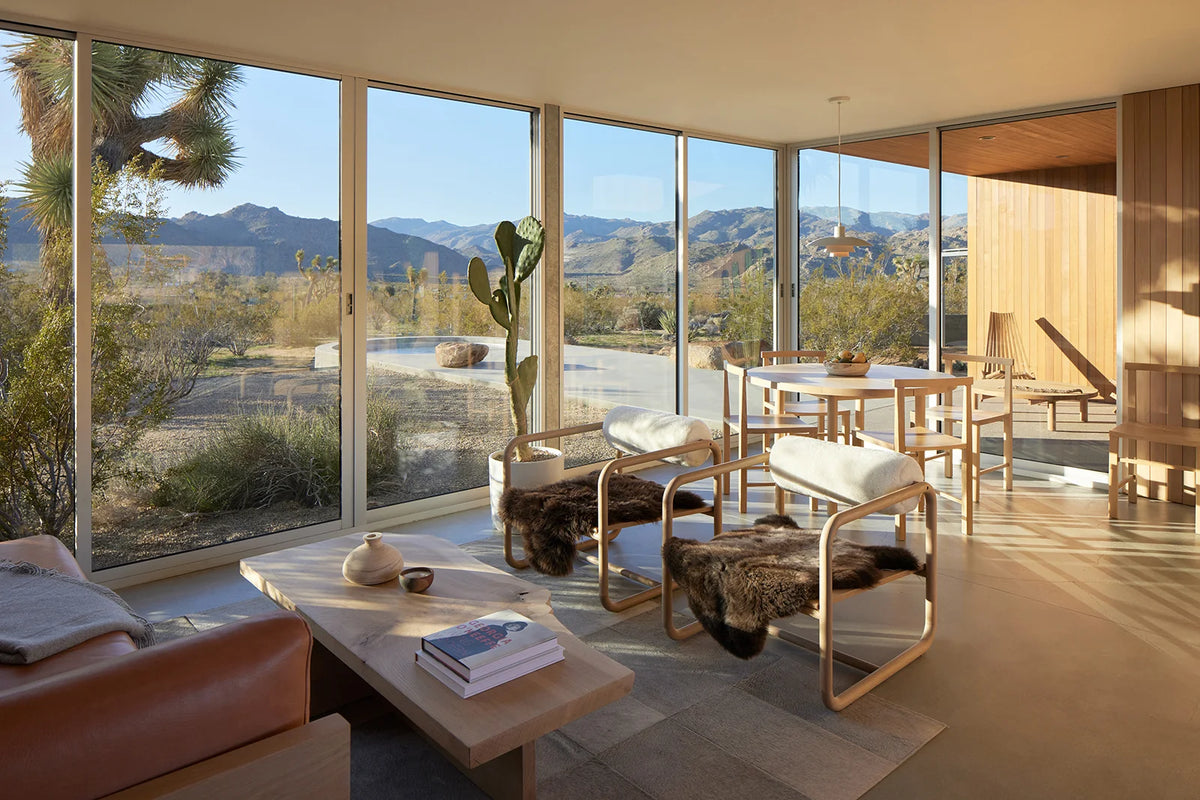 Sunlit living room with oak furniture and floor-to-ceiling desert views