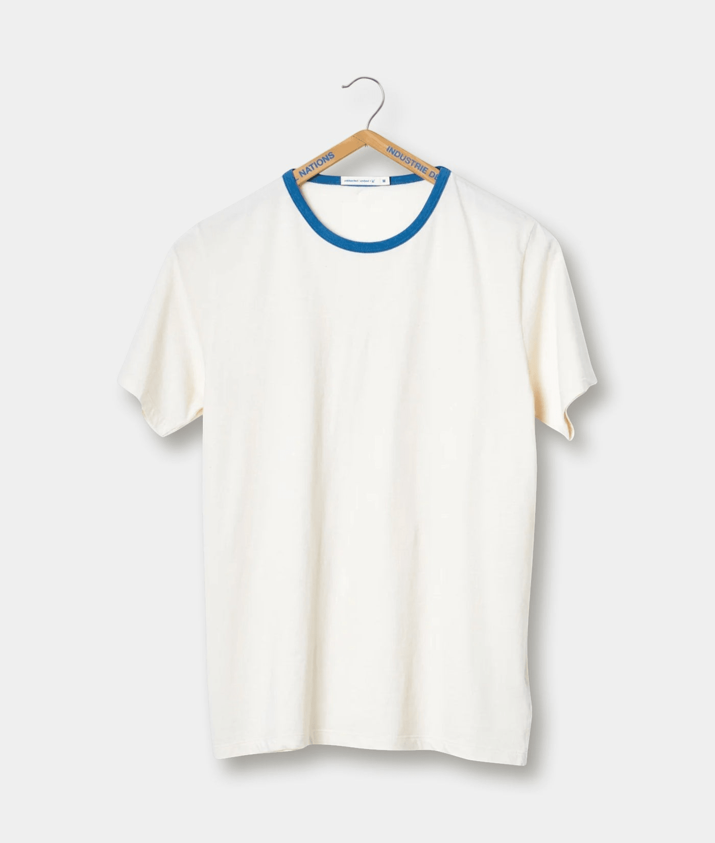 White t-shirt with blue trim, hanging on wooden hanger - Industry of All Nations
