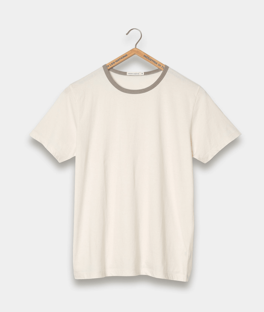 A plain white t-shirt hanging on a hanger with a gray brand label - Industry of All Nations