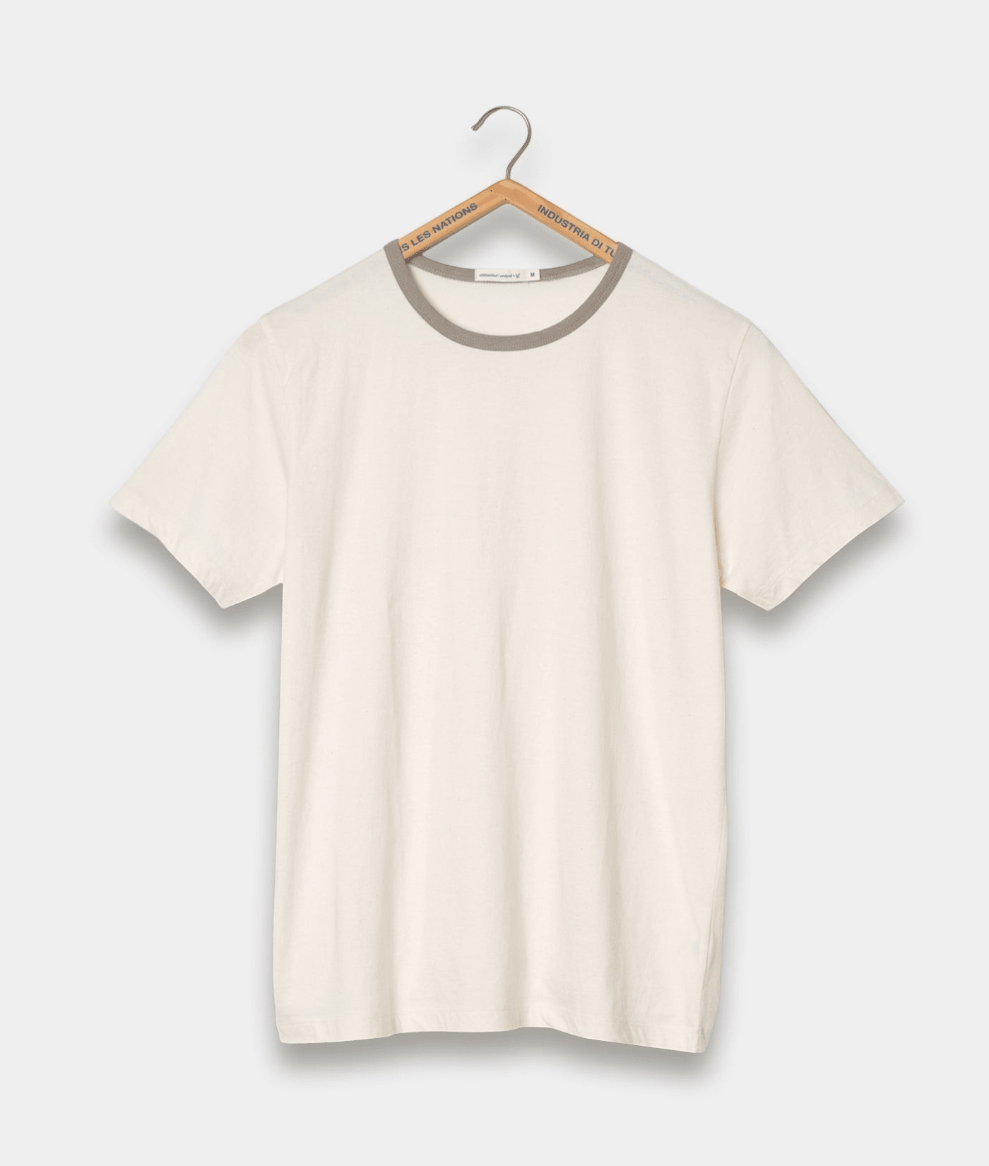 A plain white t-shirt hanging on a hanger with a gray brand label - Industry of All Nations