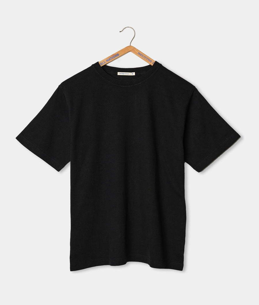 Black t-shirt with minimal branding displayed on a wooden hanger - Industry of All Nations