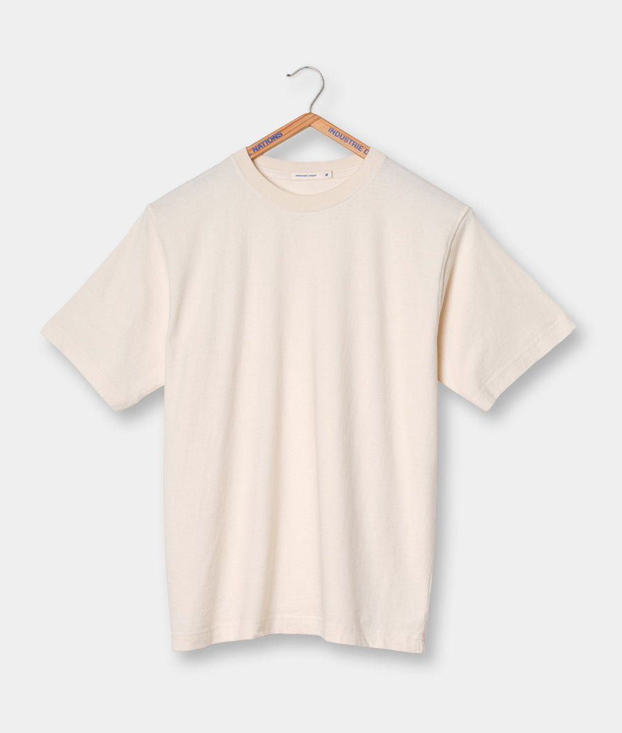 Cream-colored t-shirt hanging on a hanger with 'NATIONS' and 'INDUSTRIE' tags - Industry of All Nations