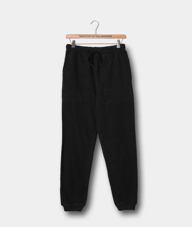 Black cotton fleece sweatpants hanging on a wooden hanger with "Industry of All Nations" printed text - Industry of All Nations