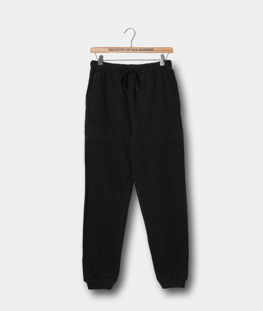 Black cotton fleece sweatpants hanging on a wooden hanger with "Industry of All Nations" printed text - Industry of All Nations