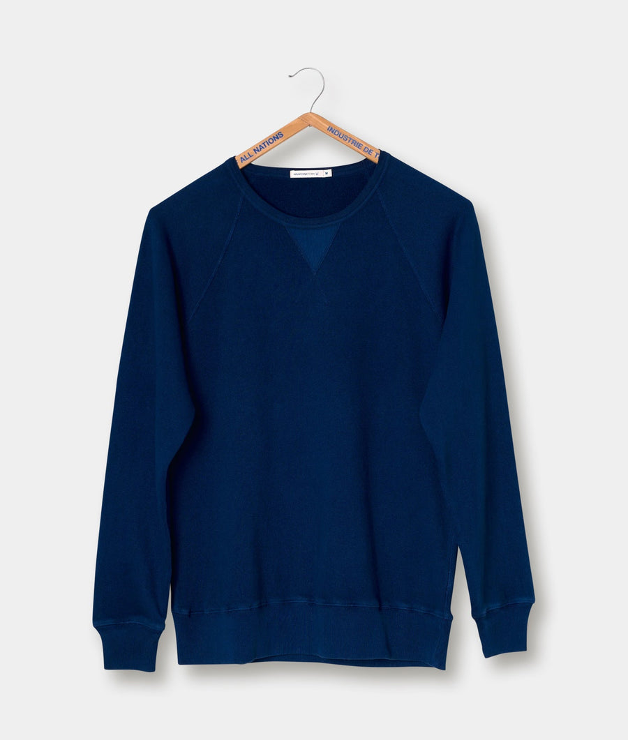 Navy blue crewneck sweater displayed on a wooden hanger against a white background - Industry of All Nations
