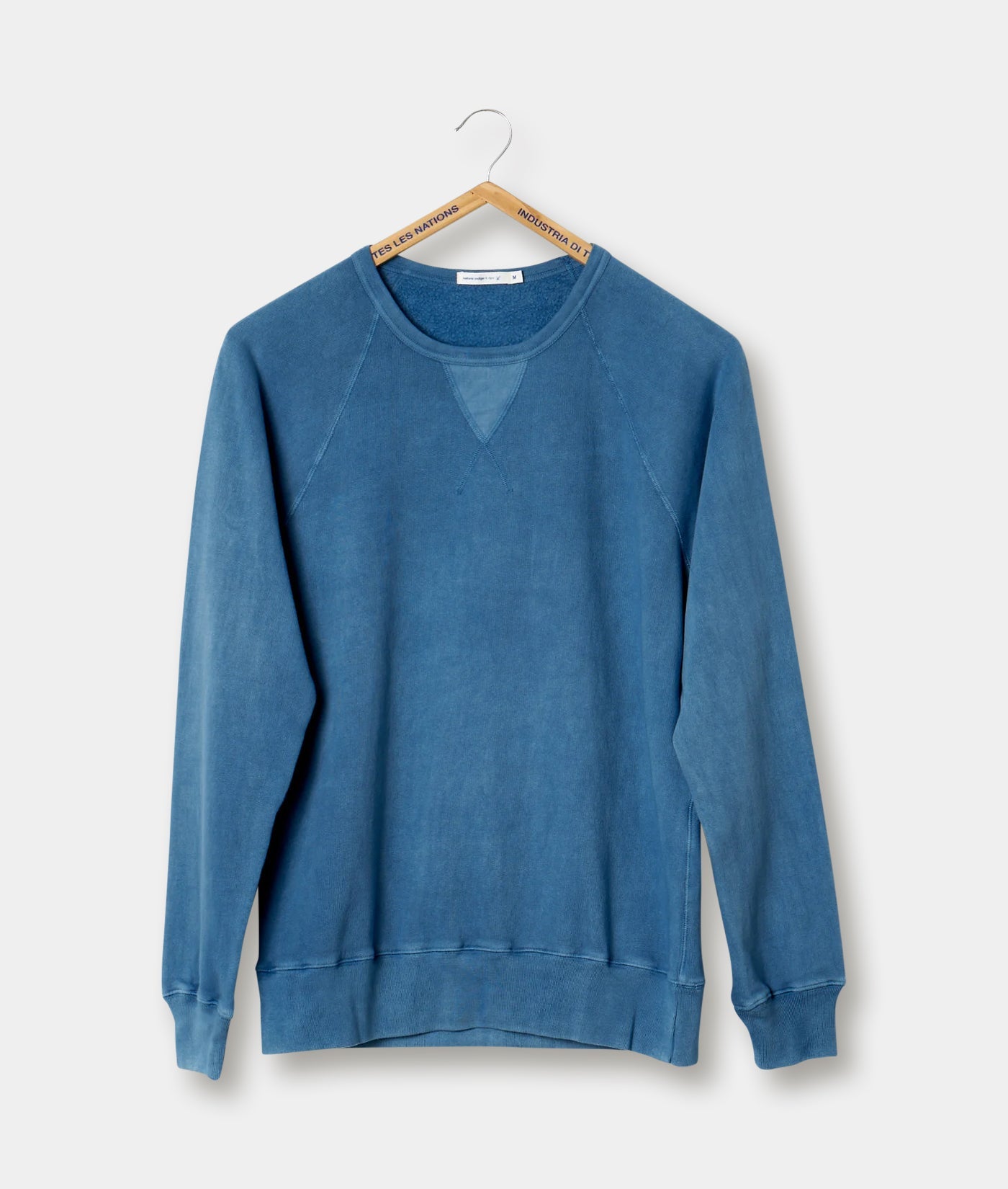 Blue cotton sweatshirt with raglan sleeves, displayed on a hanger against a plain background - Industry of All Nations