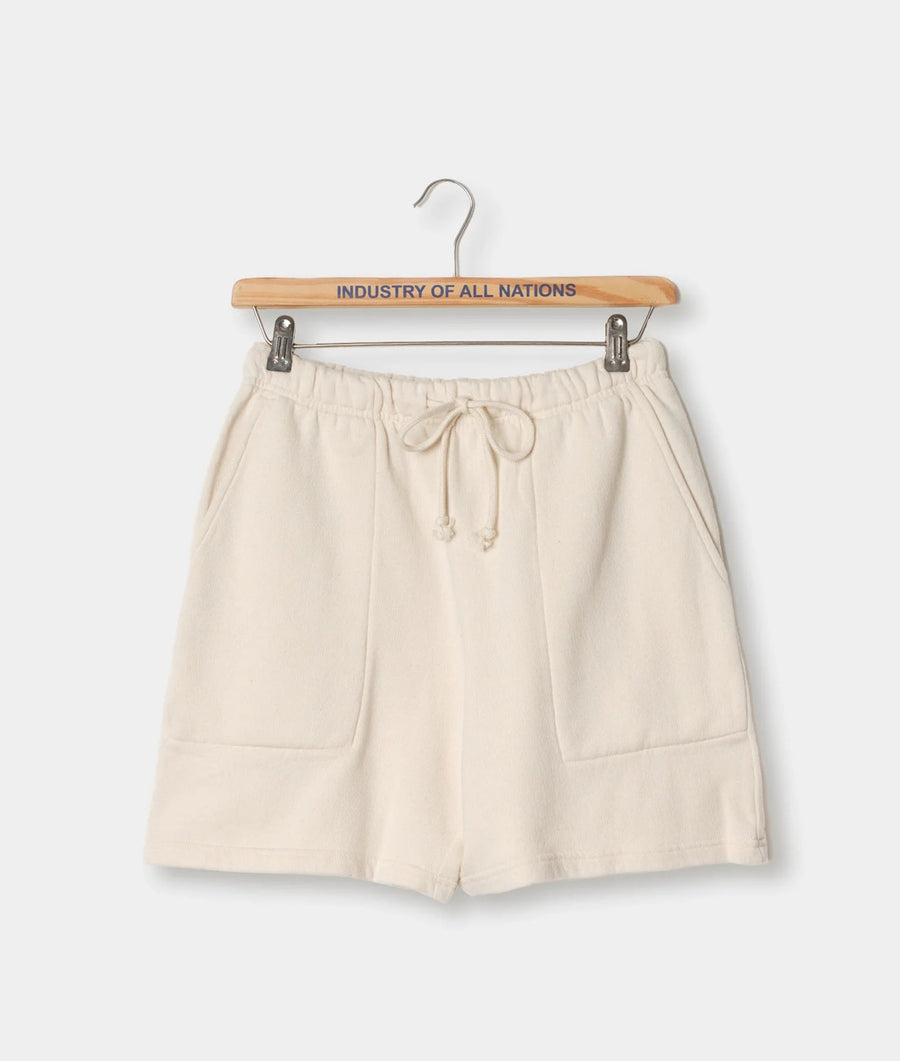 Cream-colored cotton shorts with drawstring waist, displayed on a hanger with an "Industry of All Nations" text label - Industry of All Nations