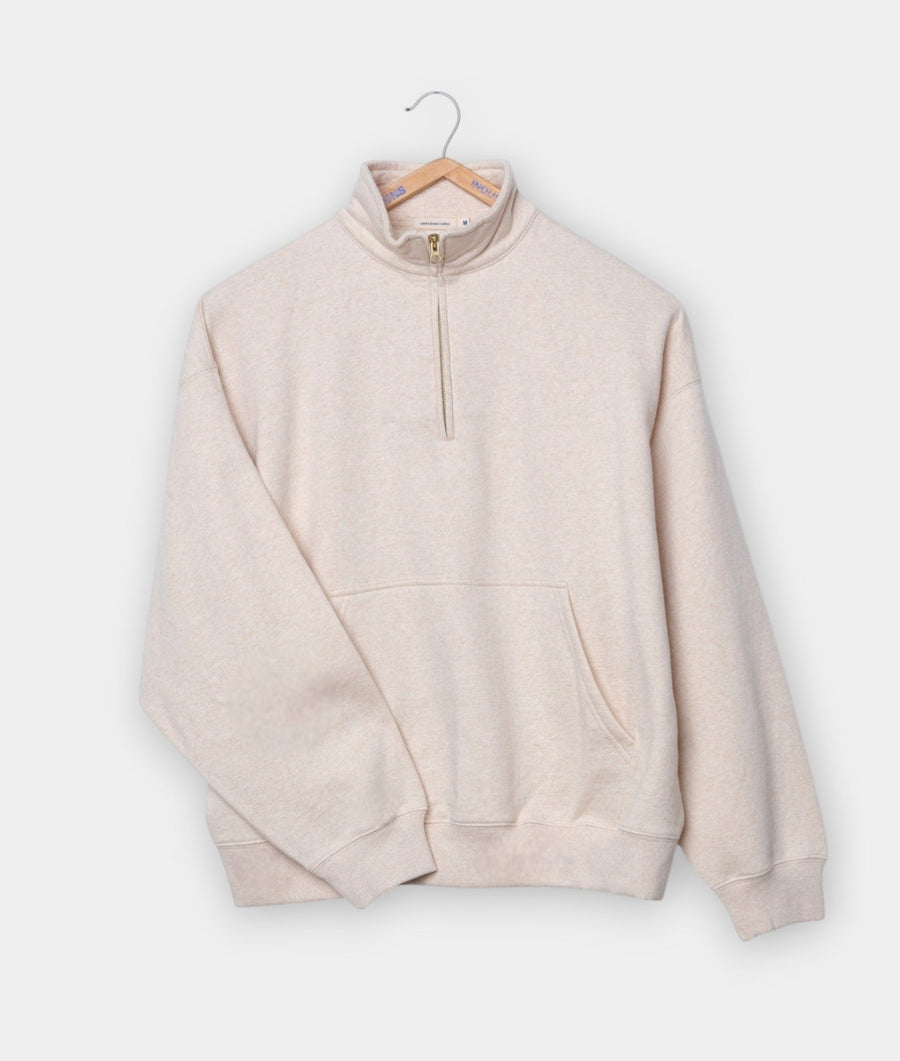 Beige fleece pullover with zipper, hanging on a wooden hanger - Industry of All Nations