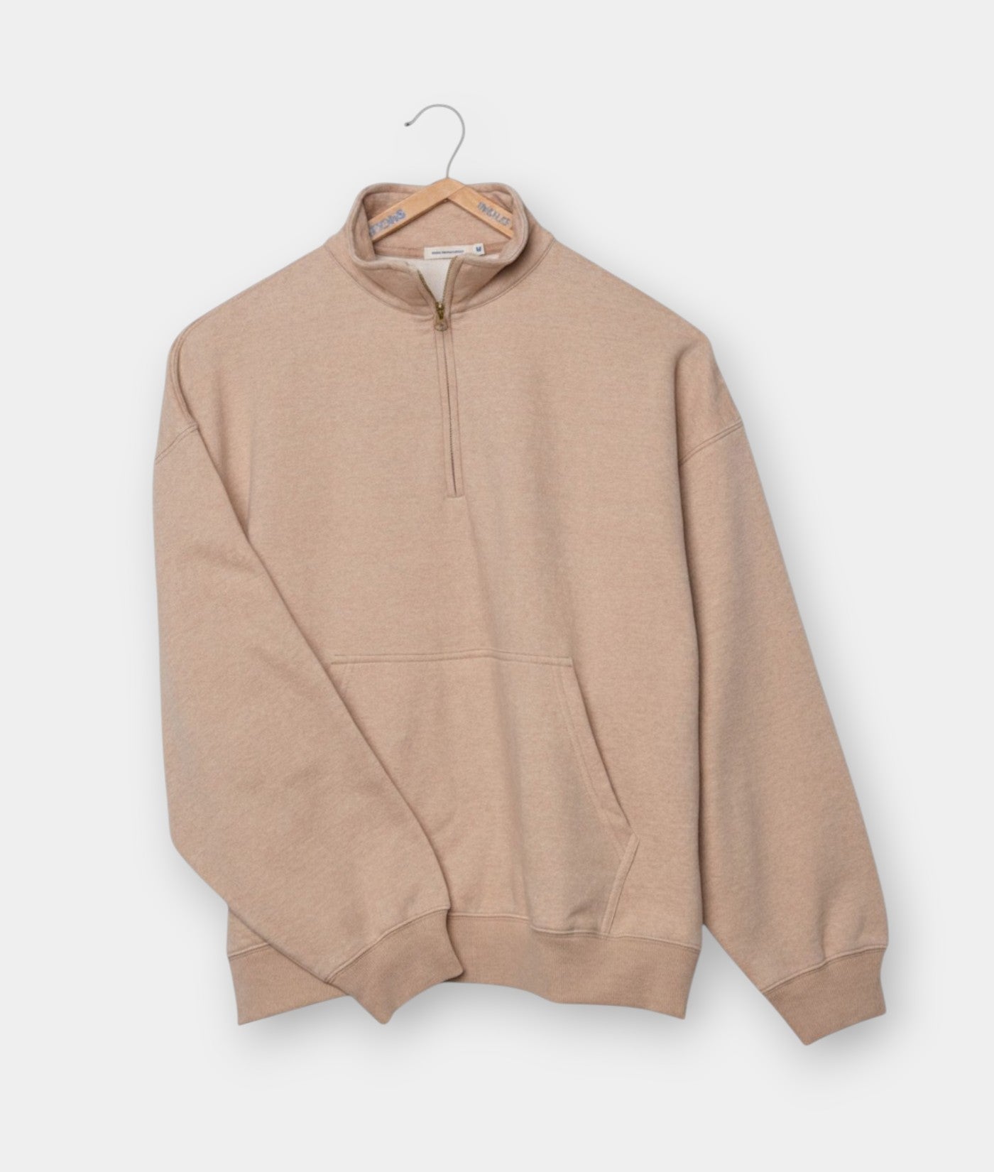 Beige quarter-zip pullover sweater displayed flat on a hanger - Industry of All Nations