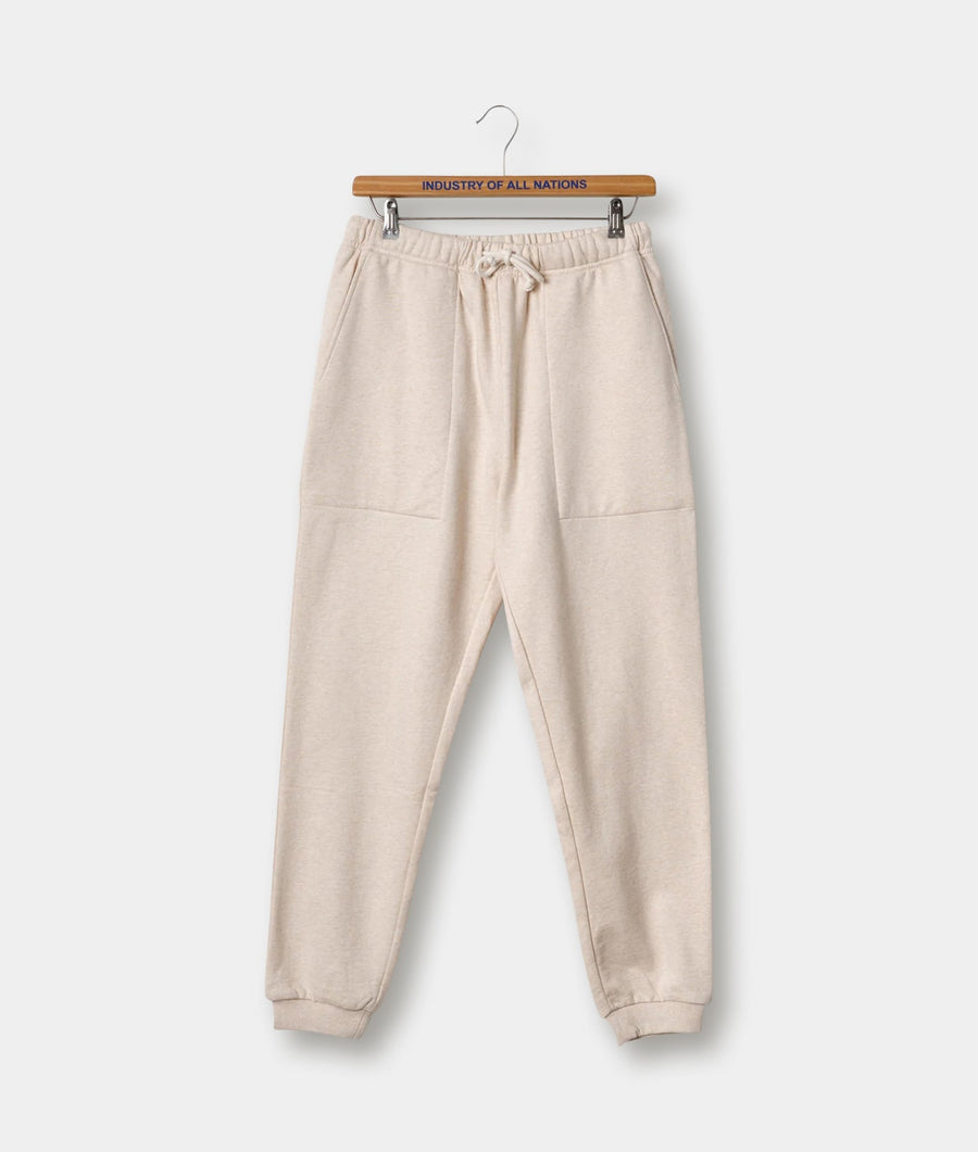 Cream-colored sweatpants with drawstring waist, displayed on a wooden hanger with "Industry of All Nations" text - Industry of All Nations