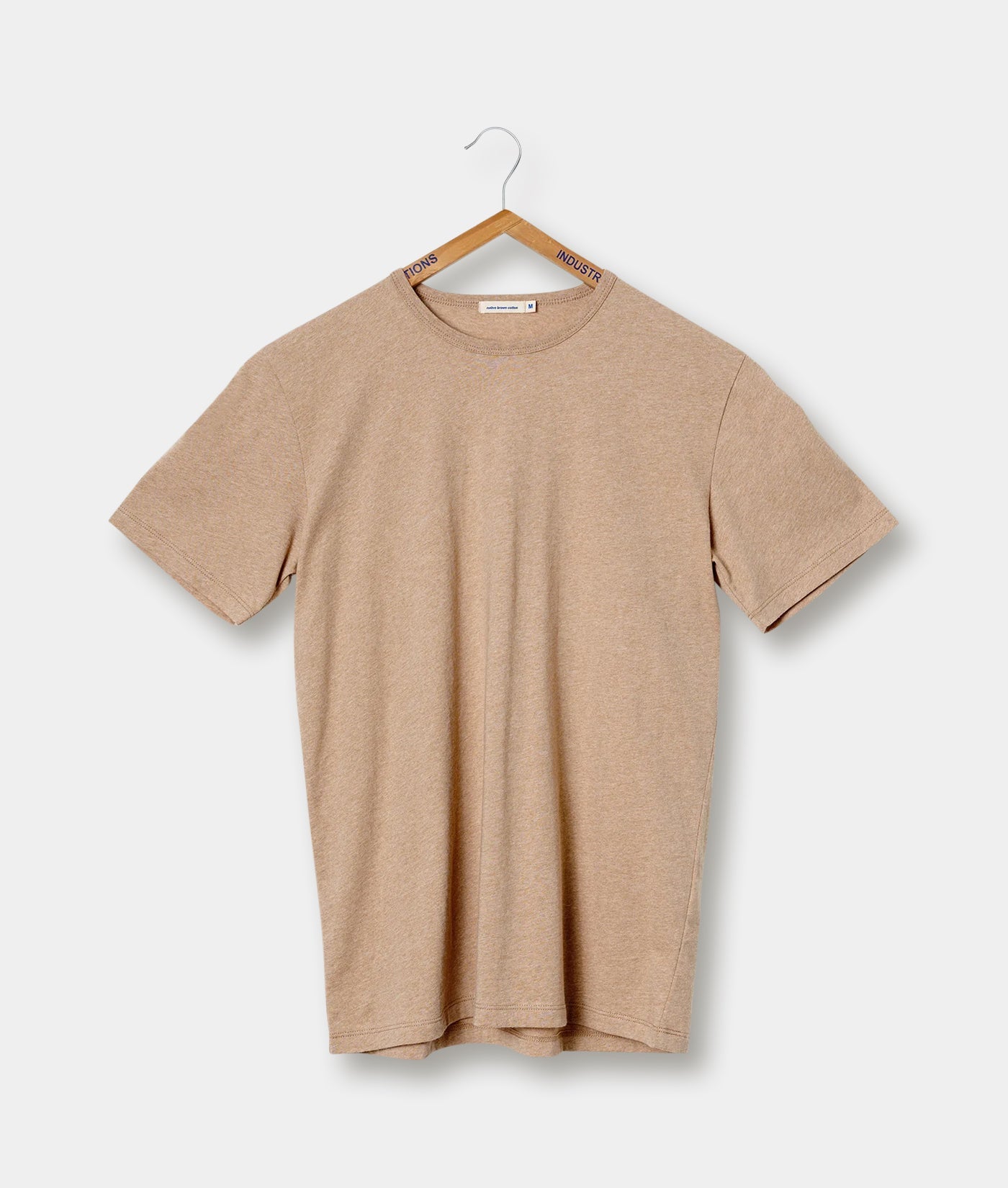 Beige crew neck t-shirt hanging on a hanger with "Industry of All Nations" branding - Industry of All Nations