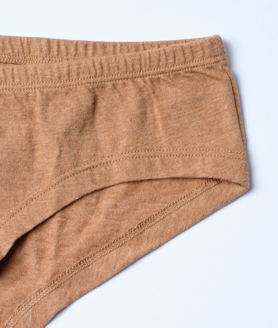 A close-up detail shot of the elastic waistband of a pair of tan-colored organic cotton briefs - Industry of All Nations
