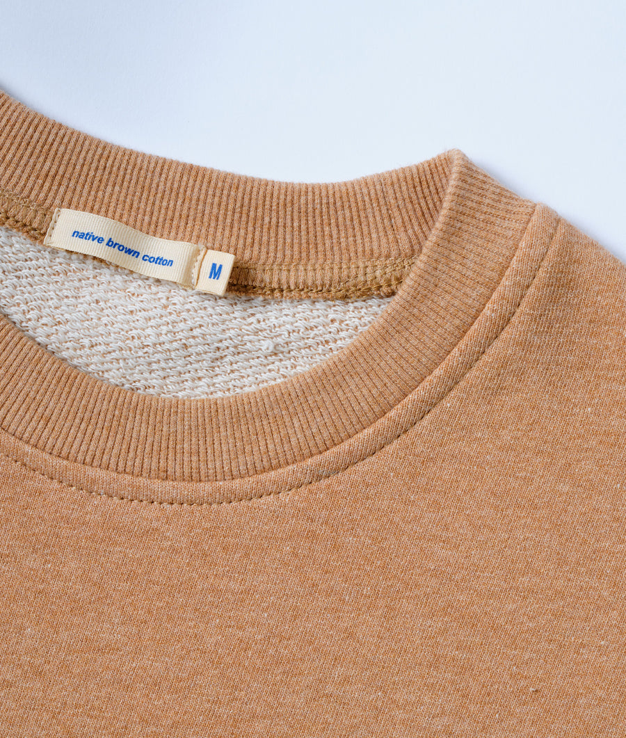 Beige, ribbed cotton sweatshirt with a 'native brown cotton' label shown in a close-up detail shot - Industry of All Nations