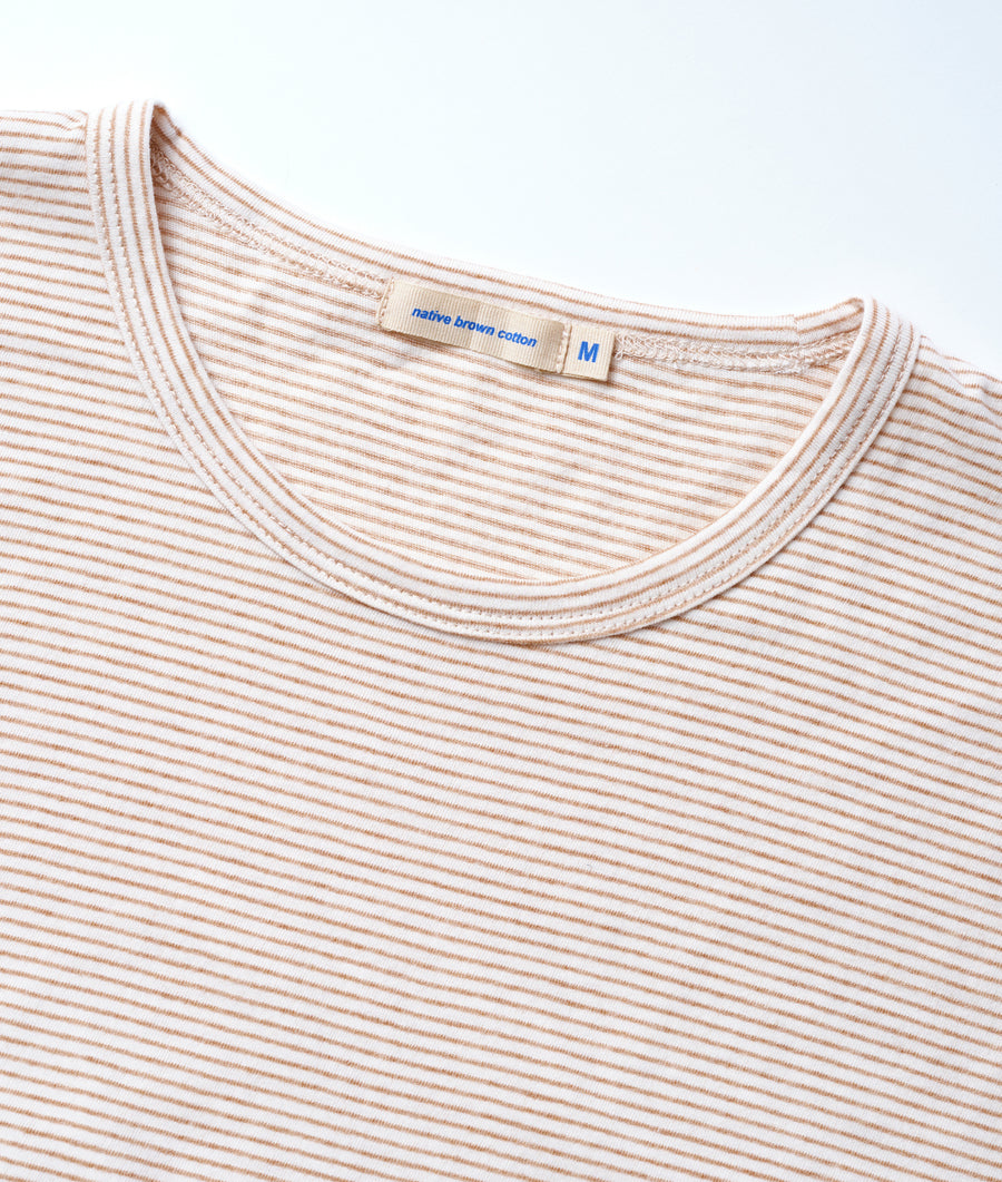 Close-up of a beige and white striped cotton t-shirt with a label that says "native brown cotton" - Industry of All Nations
