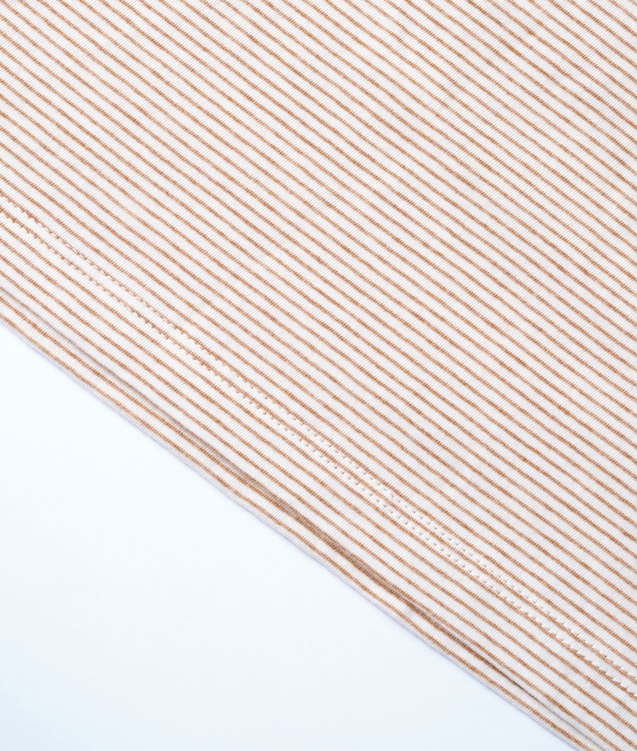 Close-up shot of a striped organic cotton fabric in off-white and orange - Industry of All Nations