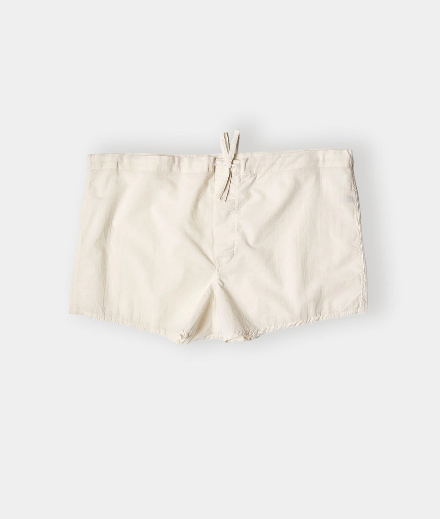Flat lay image of a pair of cream-colored cotton shorts with drawstring waist - Industry of All Nations